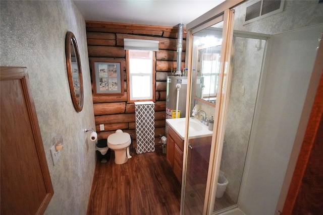 bathroom featuring water heater, vanity, hardwood / wood-style flooring, and rustic walls