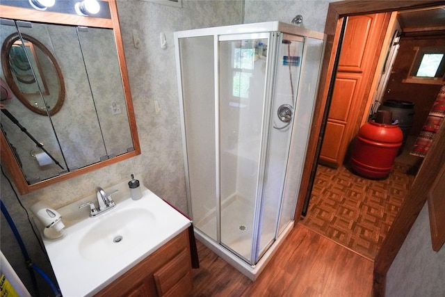 bathroom with vanity, hardwood / wood-style flooring, and walk in shower