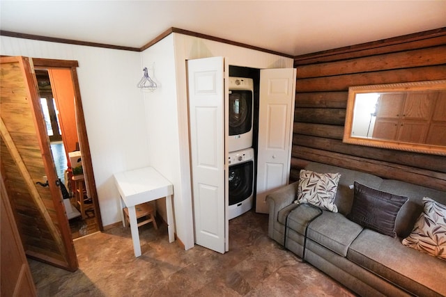 living room featuring ornamental molding, rustic walls, and stacked washer / dryer