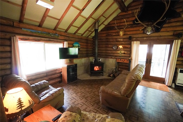 living room featuring plenty of natural light, high vaulted ceiling, french doors, and a wood stove