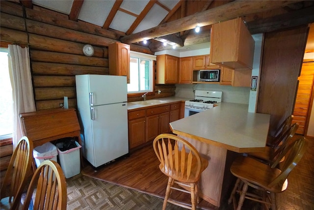 kitchen with sink, white appliances, a breakfast bar, lofted ceiling with beams, and kitchen peninsula