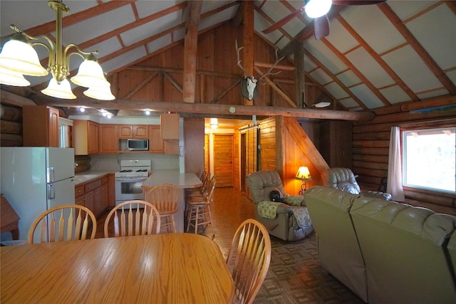 dining room with rustic walls, beam ceiling, a chandelier, and high vaulted ceiling