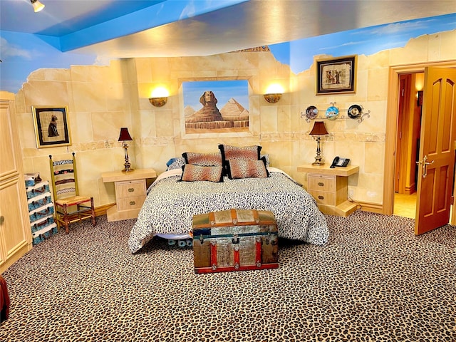 tiled bedroom featuring beam ceiling and tile walls