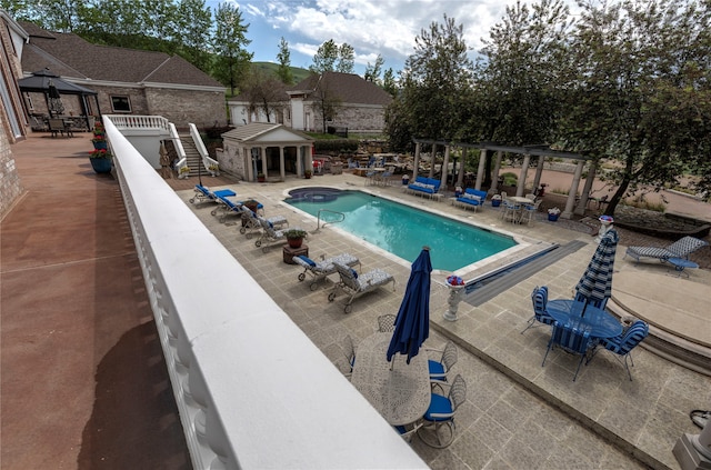 view of swimming pool featuring a patio area and an outdoor structure