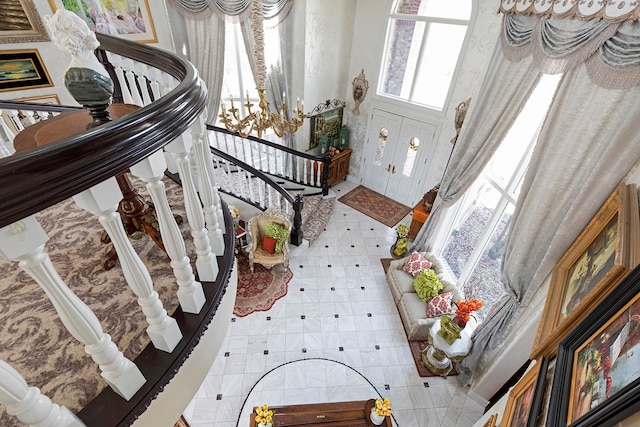 interior space featuring an inviting chandelier, tile floors, and a towering ceiling