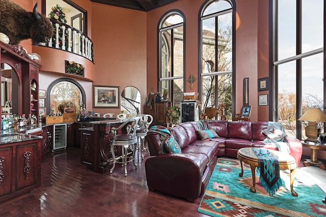 living room with a towering ceiling, dark hardwood / wood-style floors, and wine cooler