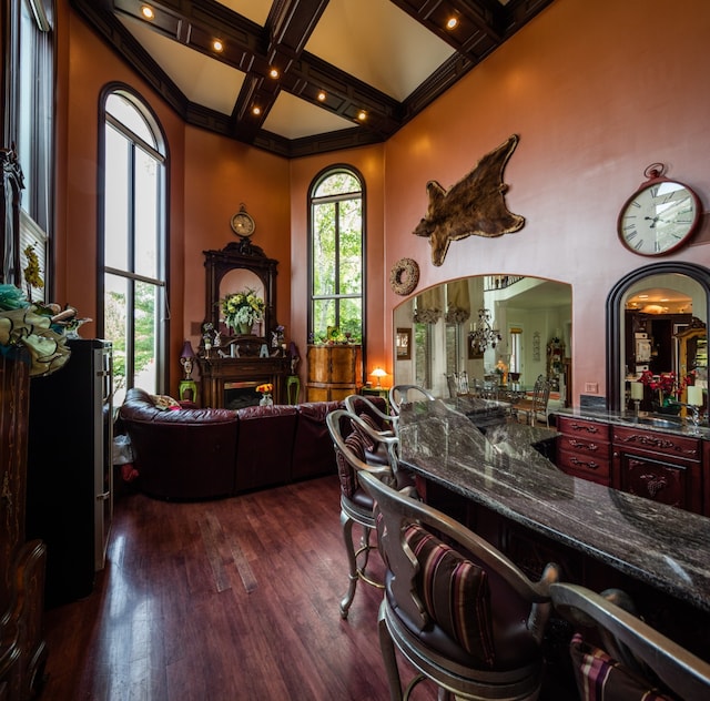 interior space with coffered ceiling, ornamental molding, dark hardwood / wood-style flooring, and beamed ceiling