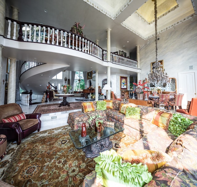 interior space with a towering ceiling, a chandelier, and ornate columns