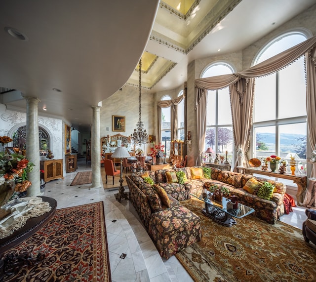 interior space with decorative columns, a chandelier, a high ceiling, and light tile floors