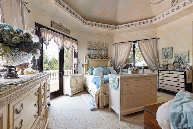 bedroom with a towering ceiling, access to outside, light carpet, and french doors