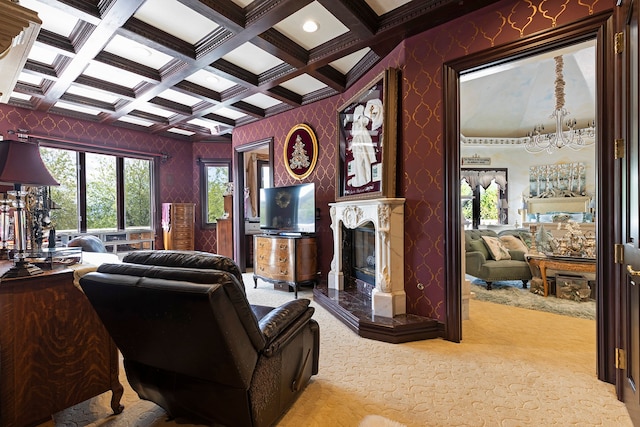 carpeted living room with coffered ceiling, a notable chandelier, a high end fireplace, and beam ceiling