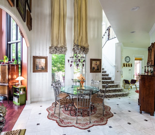 tiled dining area with crown molding and a towering ceiling