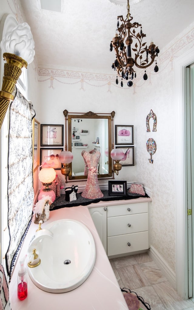 bathroom with tile floors, a notable chandelier, and vanity