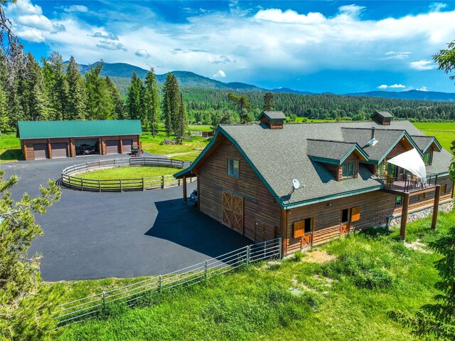 surrounding community with a rural view, a mountain view, and a lawn