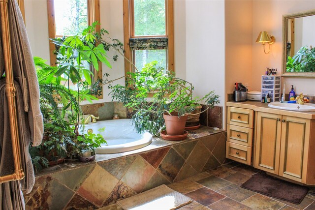 bathroom with vanity and tiled bath