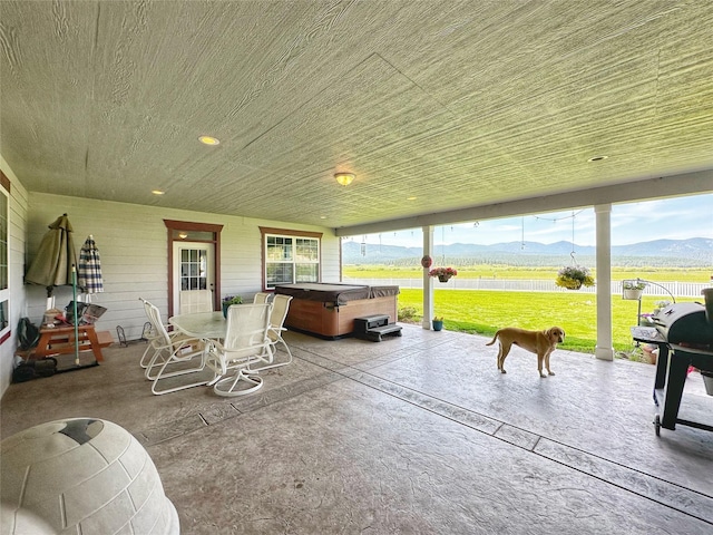 view of patio featuring a grill, a mountain view, and a hot tub