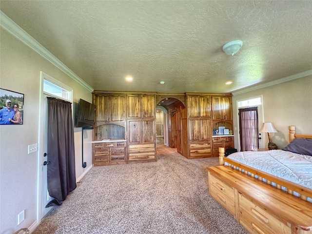 bedroom with a textured ceiling, crown molding, and light carpet