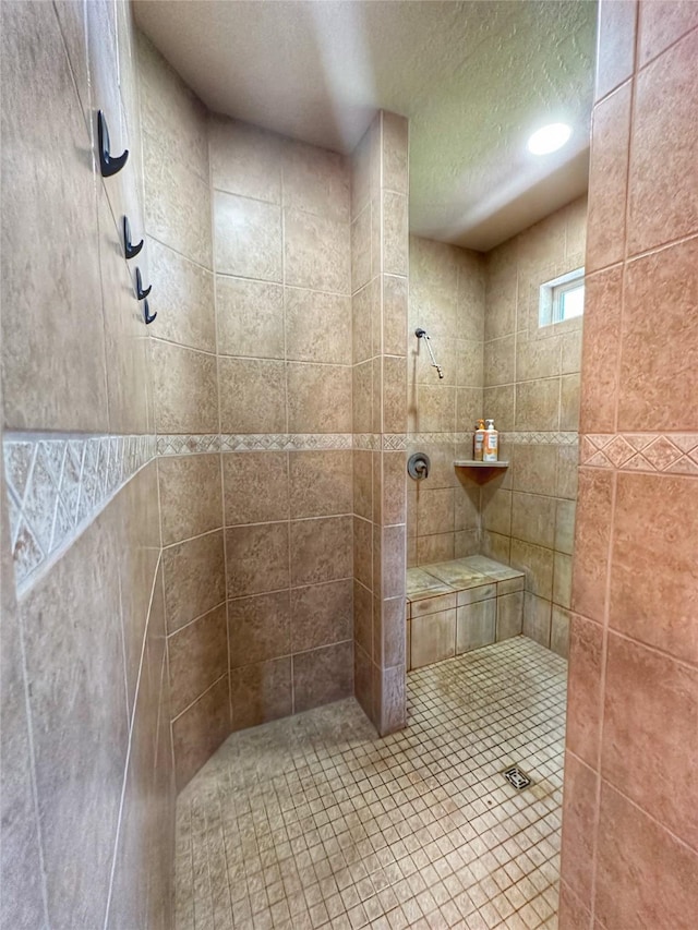 bathroom featuring a tile shower and a textured ceiling