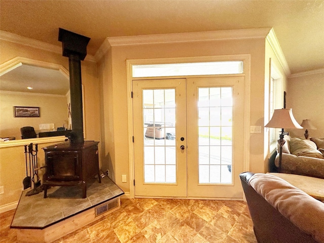 doorway featuring a wood stove, french doors, and ornamental molding