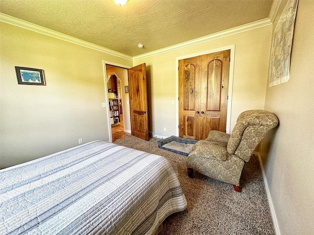 carpeted bedroom featuring a textured ceiling, a closet, and crown molding