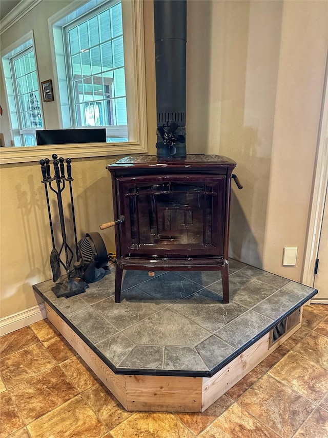 details featuring a wood stove and crown molding