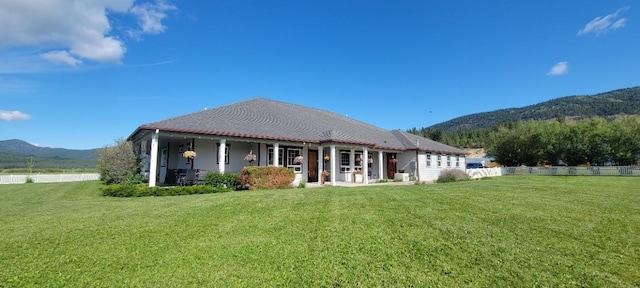 back of property with a lawn and a mountain view