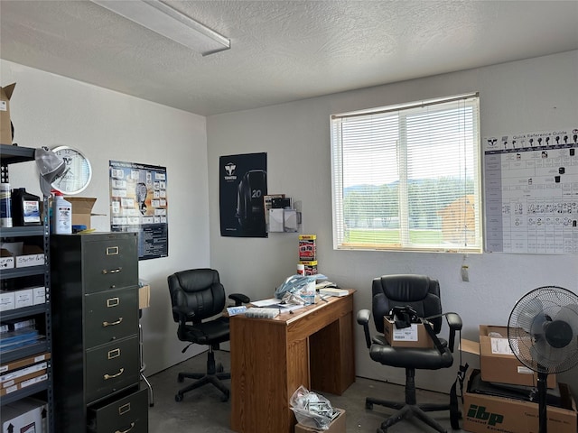 office area with a textured ceiling and concrete floors