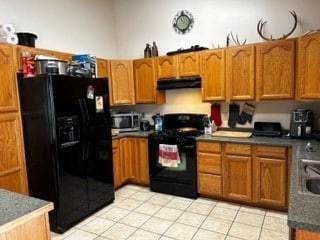 kitchen with light tile floors, black fridge with ice dispenser, and electric range oven