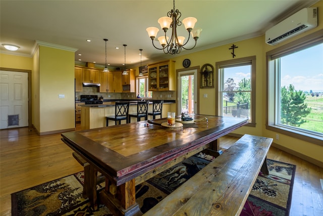 kitchen with pendant lighting, black appliances, a kitchen breakfast bar, ornamental molding, and tasteful backsplash