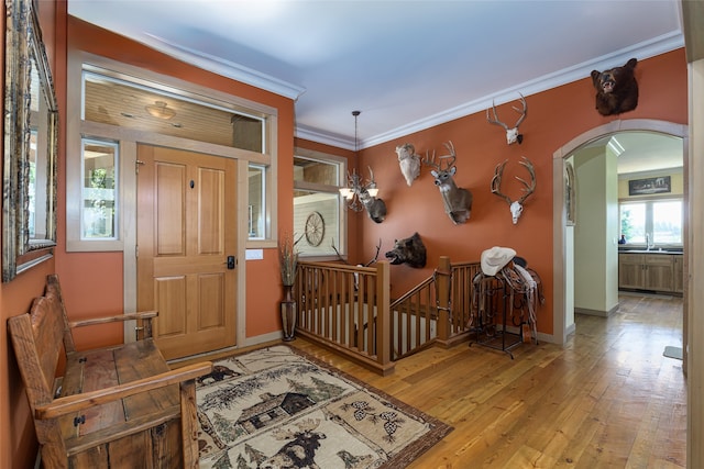 dining area featuring ornamental molding, light wood-type flooring, an AC wall unit, and a notable chandelier