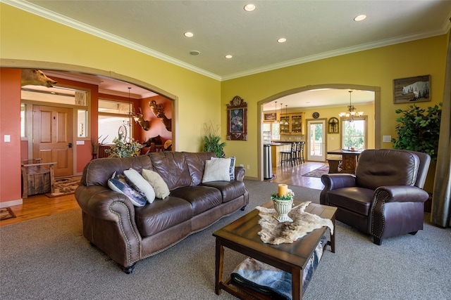 carpeted living room featuring an inviting chandelier and ornamental molding