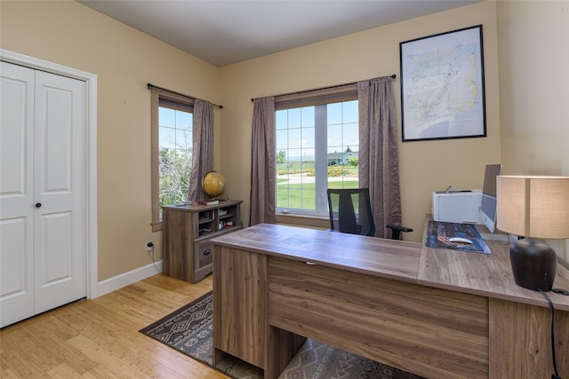 home office with light hardwood / wood-style flooring