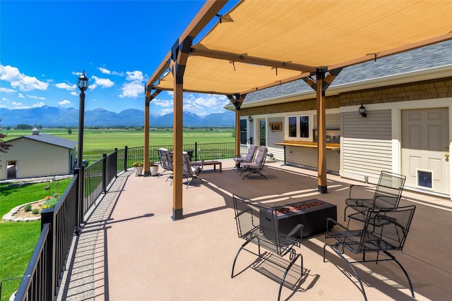 view of patio / terrace with a mountain view, a rural view, and a fire pit