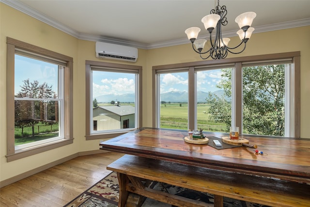 dining room featuring an inviting chandelier, an AC wall unit, ornamental molding, a wealth of natural light, and light hardwood / wood-style floors