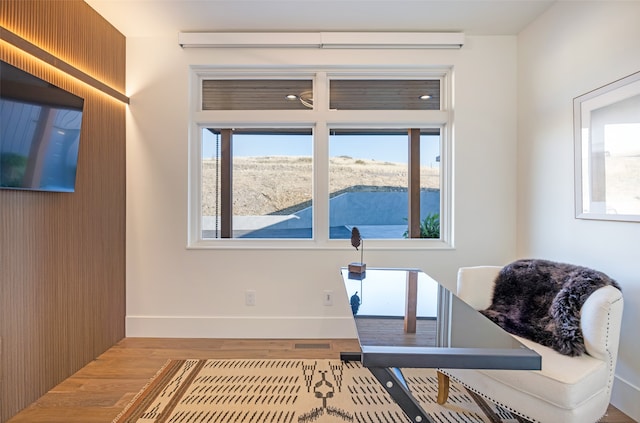 office area with a wealth of natural light and hardwood / wood-style floors