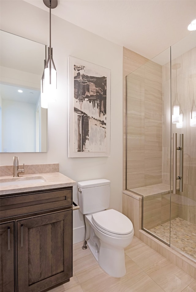 bathroom with tile patterned flooring, toilet, a shower with door, and vanity