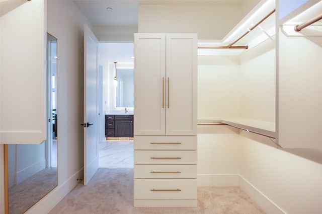 walk in closet with light colored carpet and sink