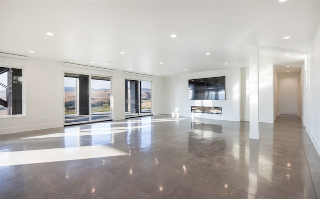 unfurnished living room featuring concrete floors