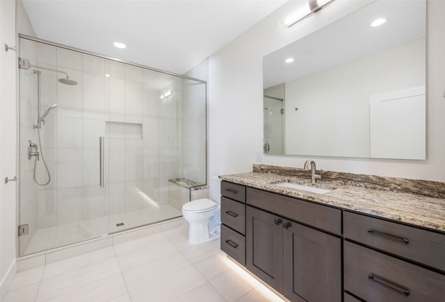 bathroom featuring a shower with shower door, tile patterned flooring, toilet, and vanity