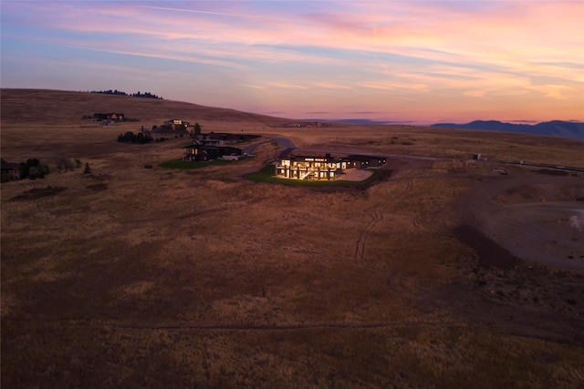 aerial view at dusk featuring a rural view and a mountain view