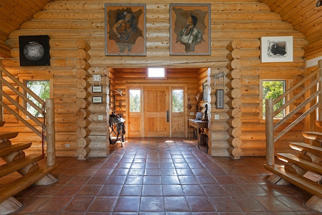 tiled entrance foyer featuring log walls, high vaulted ceiling, and wood ceiling