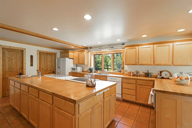 kitchen with light brown cabinetry, a center island, butcher block counters, white appliances, and light tile flooring