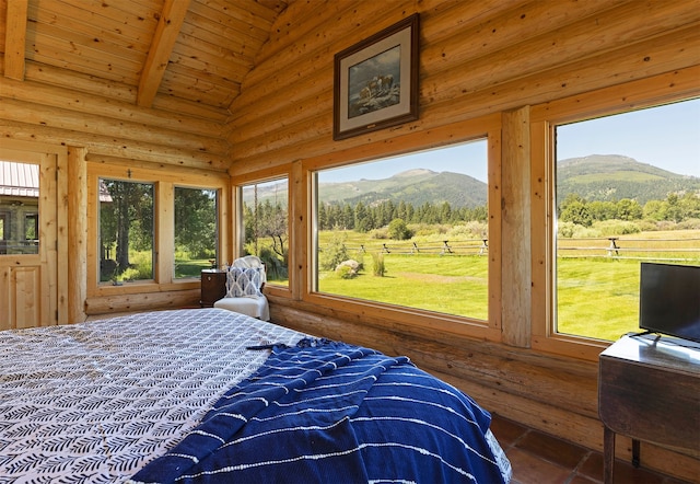 bedroom featuring a mountain view, log walls, lofted ceiling with beams, and wooden ceiling