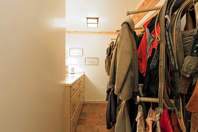 spacious closet with dark tile flooring