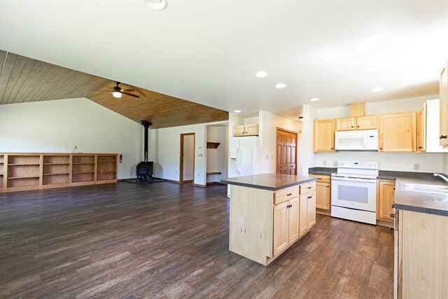 kitchen with light brown cabinets, dark wood-type flooring, a wood stove, ceiling fan, and white appliances