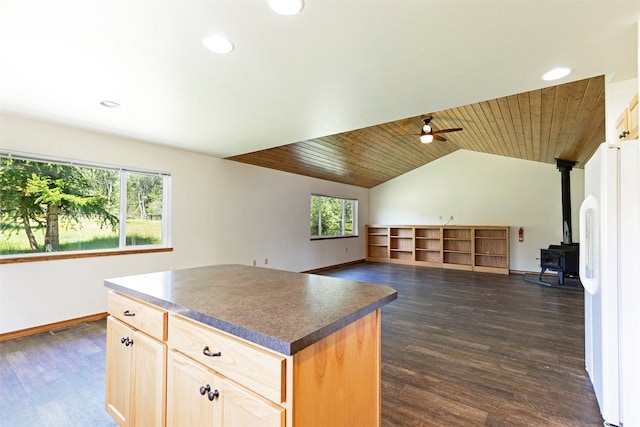 kitchen with a wood stove, ceiling fan, white fridge, wood ceiling, and dark hardwood / wood-style floors