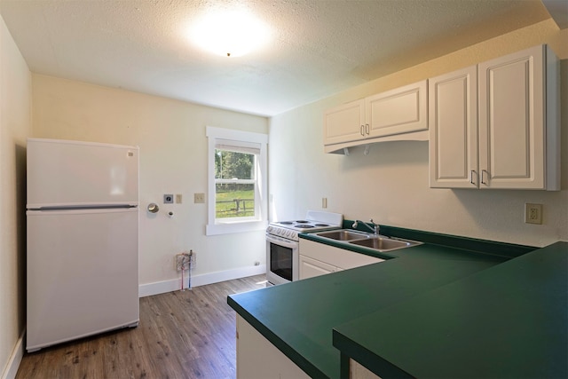 kitchen with white appliances, hardwood / wood-style floors, white cabinets, and sink