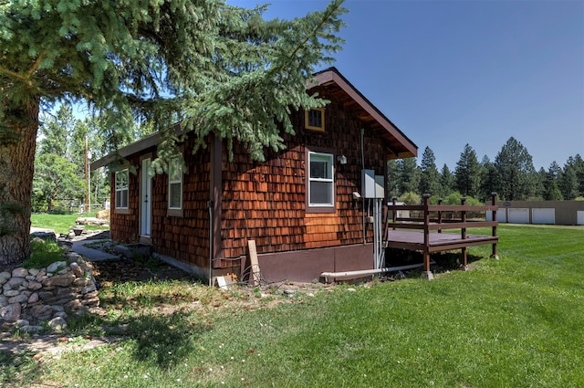 view of side of property with a deck and a lawn