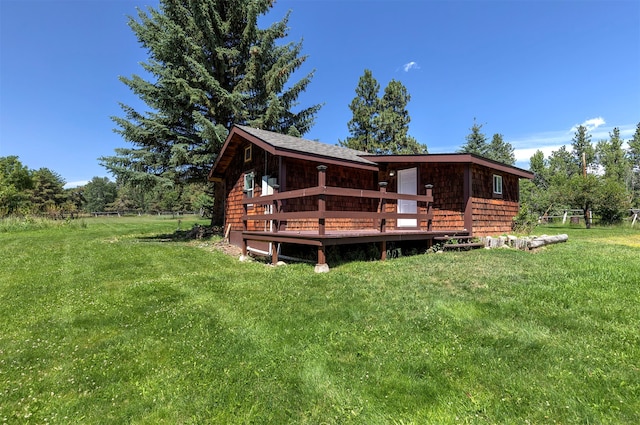 rear view of property with a wooden deck and a yard