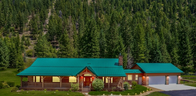 view of front facade featuring a porch, a garage, and a front lawn